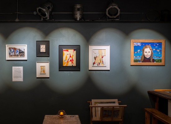 Dark grey gallery walls offset paintings by Red in her exhibition, we learnt to fly. This exhibition showcases Red's collection of work "We Learnt to Fly" about recovery from domestic abuse